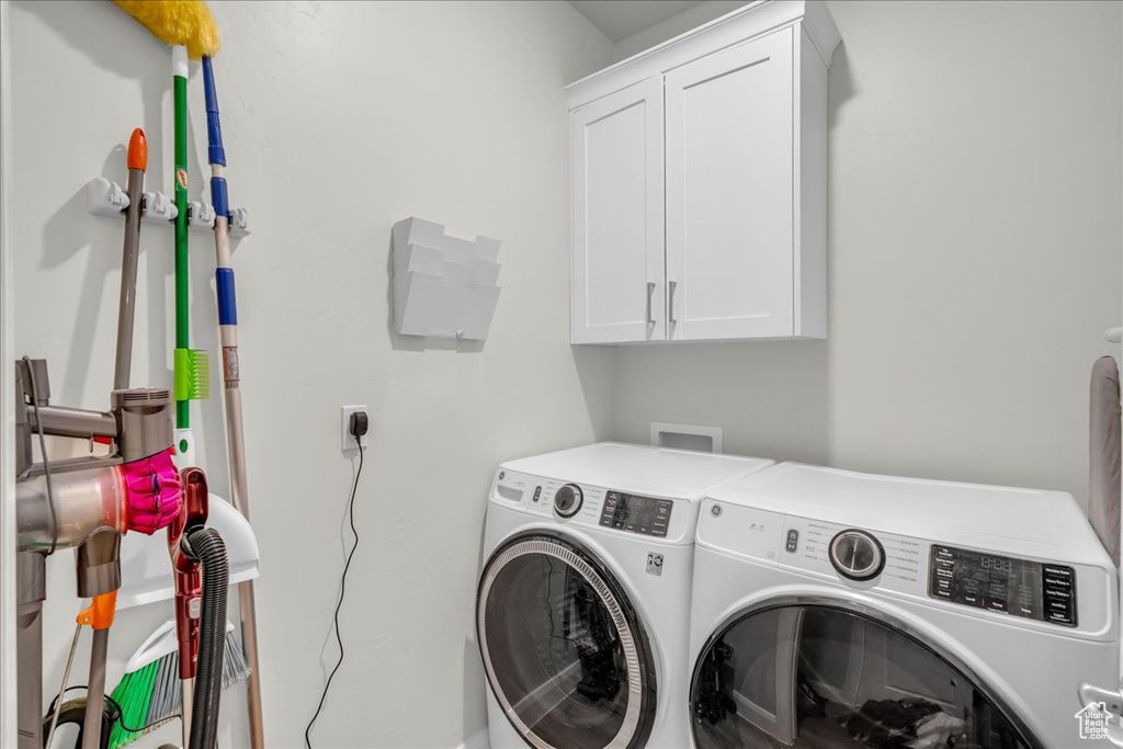 Laundry room with cabinet space and washer and clothes dryer