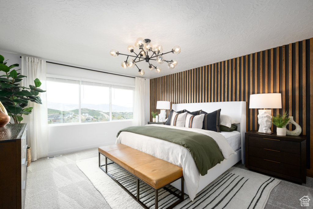 Bedroom featuring baseboards, light carpet, and an inviting chandelier