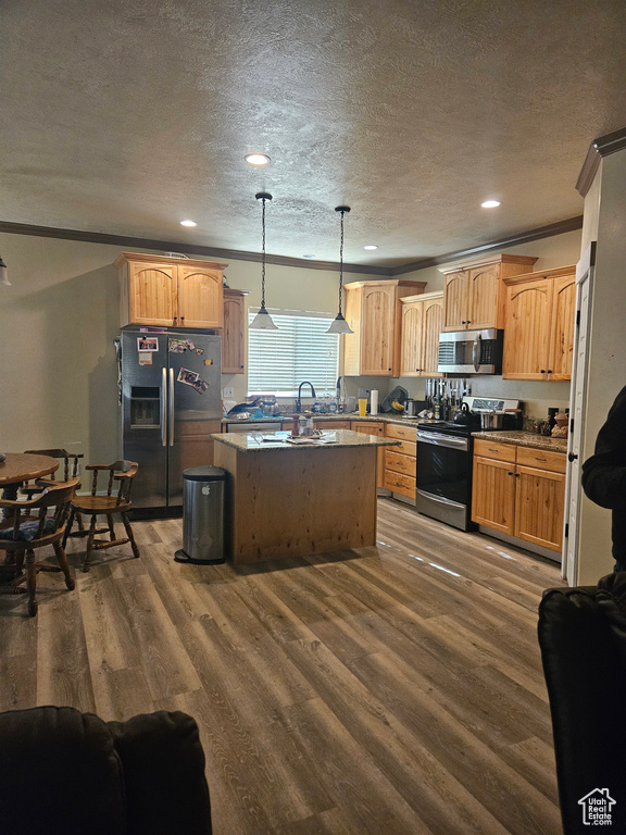 Kitchen featuring a kitchen island, stainless steel appliances, a textured ceiling, and dark wood finished floors