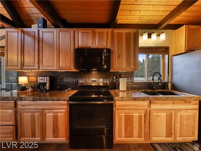 Kitchen with a sink, beam ceiling, black appliances, and wooden ceiling