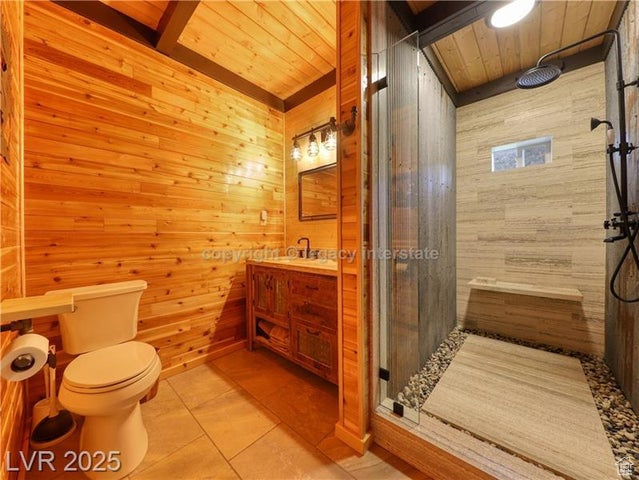 Bathroom with tile patterned flooring, wood walls, wood ceiling, and a shower stall