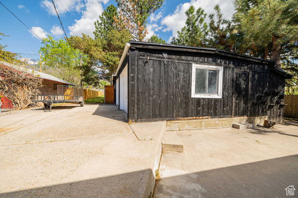 View of outbuilding featuring fence