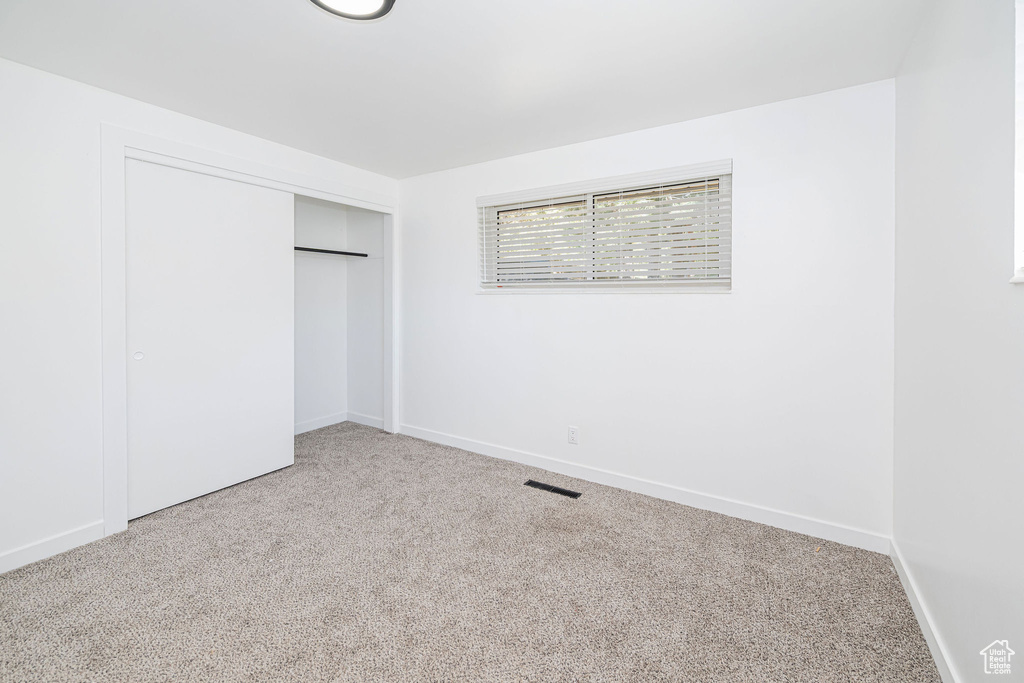 Unfurnished bedroom featuring baseboards, visible vents, carpet, and a closet