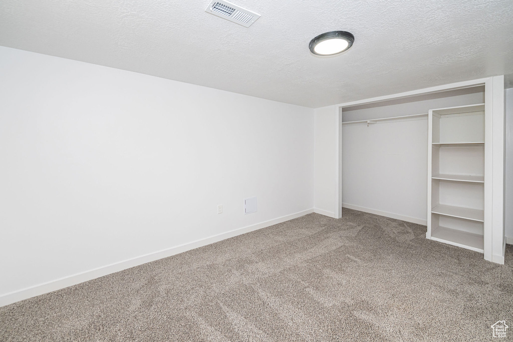 Unfurnished bedroom featuring a closet, baseboards, carpet flooring, and visible vents