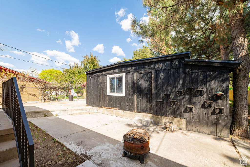 View of outbuilding featuring fence