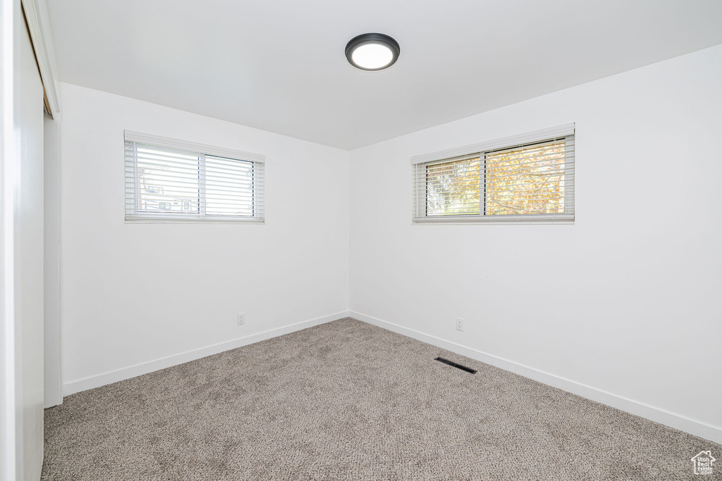 Spare room featuring baseboards, visible vents, and carpet