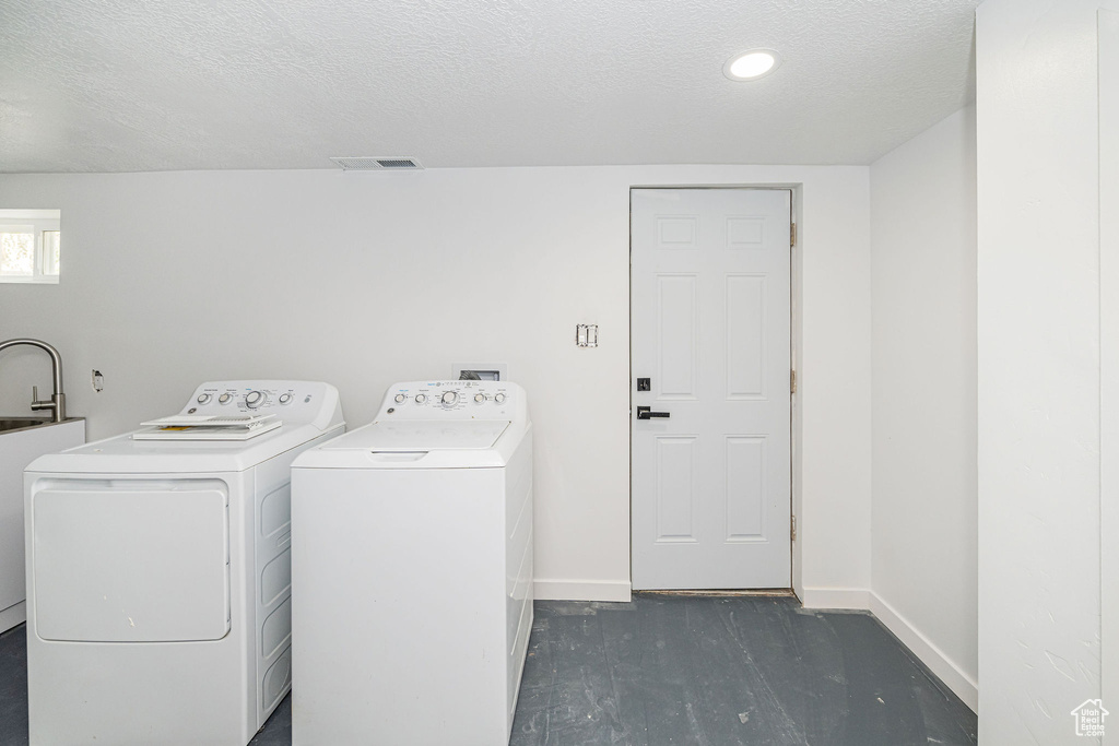 Laundry room with laundry area, a textured ceiling, visible vents, washing machine and dryer, and baseboards