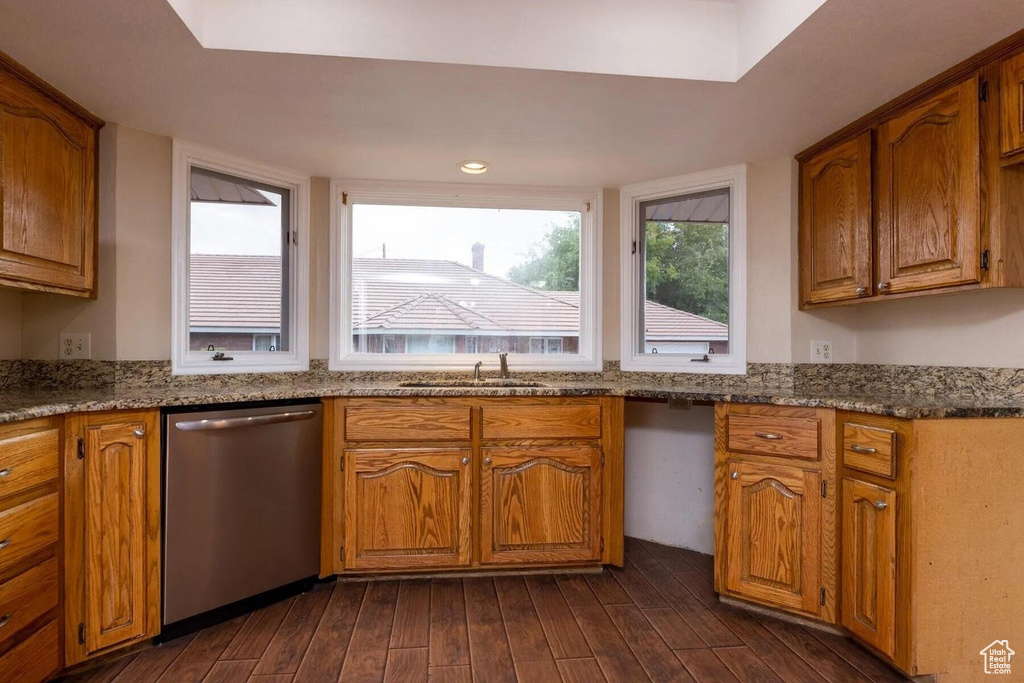 Kitchen featuring stainless steel dishwasher, a sink, dark wood-style flooring, and brown cabinets