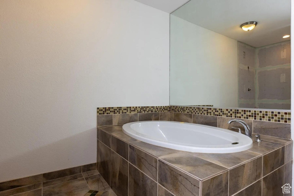 Full bathroom with baseboards, tile patterned flooring, and a garden tub