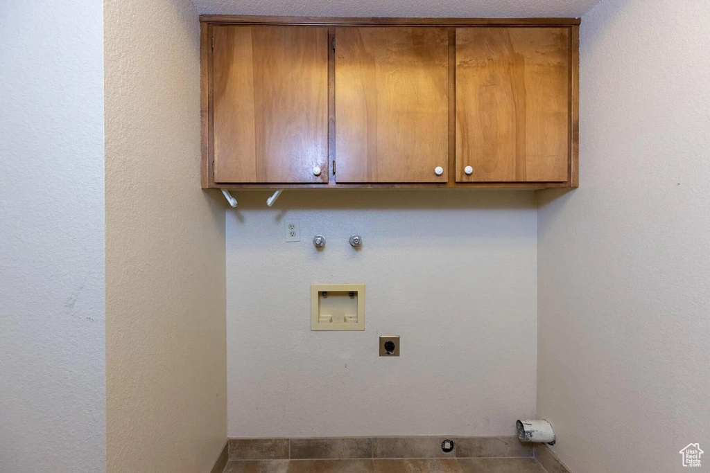 Washroom with hookup for a washing machine, cabinet space, hookup for a gas dryer, and hookup for an electric dryer