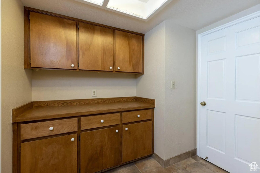 Kitchen featuring dark countertops, brown cabinetry, and baseboards
