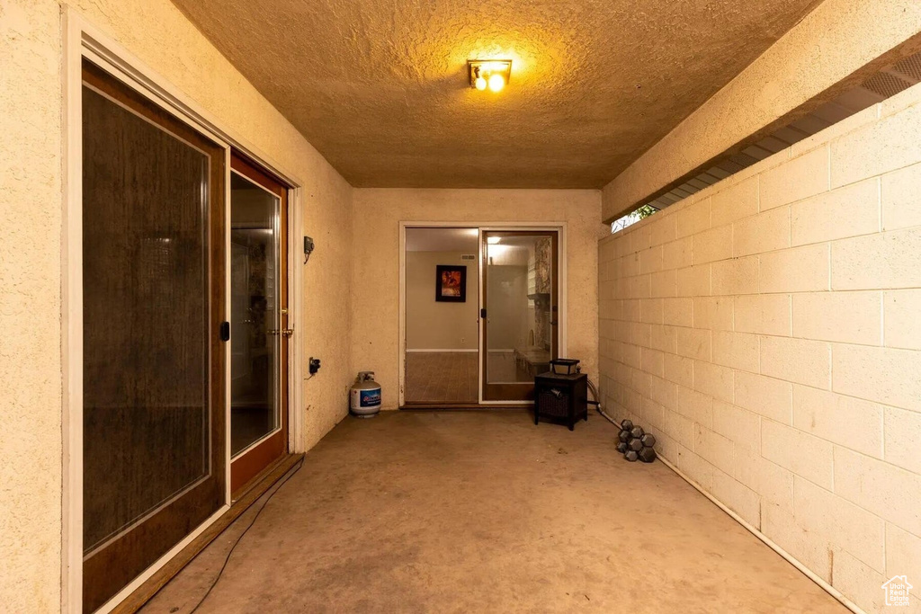 Interior space with a textured ceiling and concrete flooring