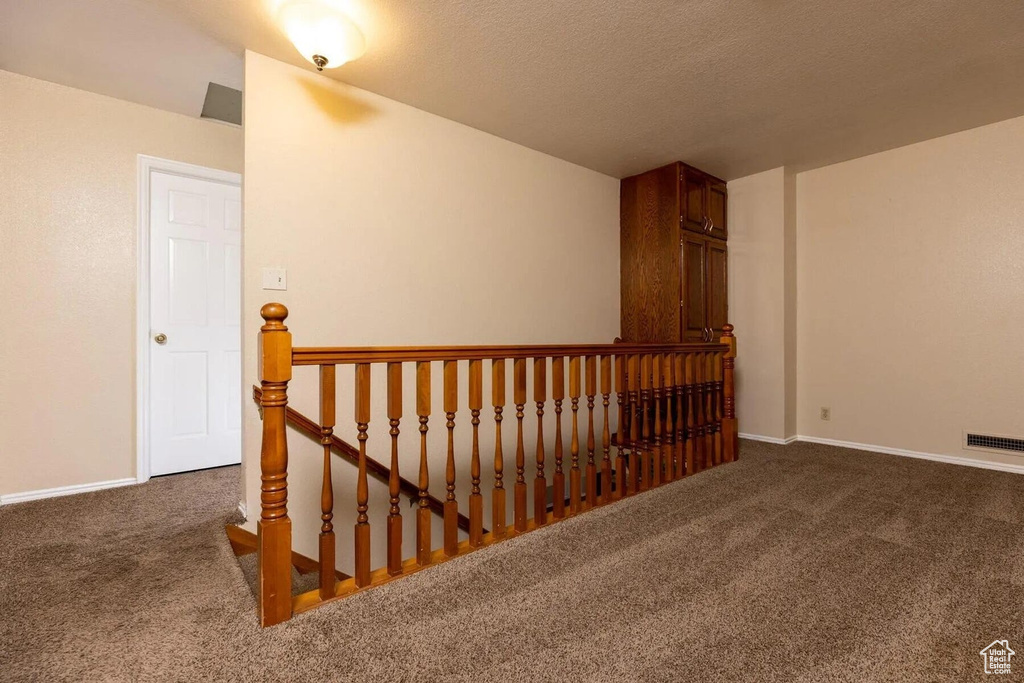 Stairway with visible vents, baseboards, carpet, and lofted ceiling