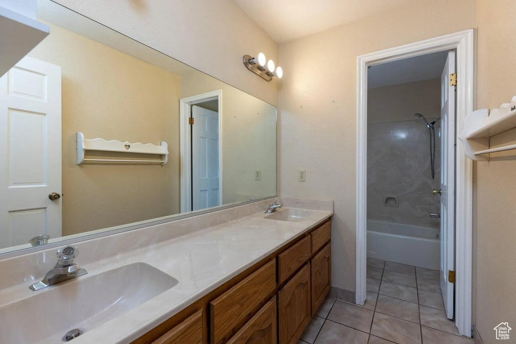Full bath with double vanity, shower / washtub combination, a sink, and tile patterned flooring
