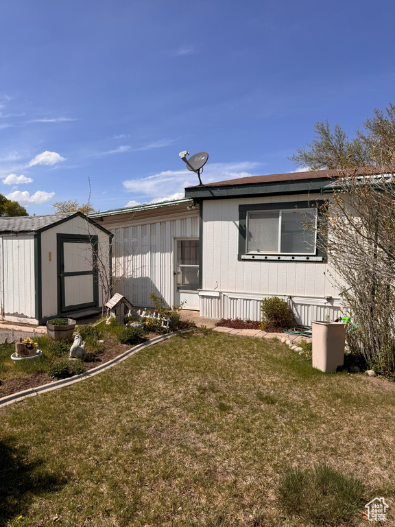 Exterior space with a lawn, an outdoor structure, and a shed