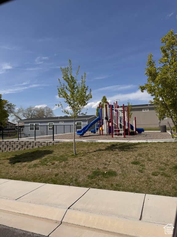 Community play area with a lawn and fence