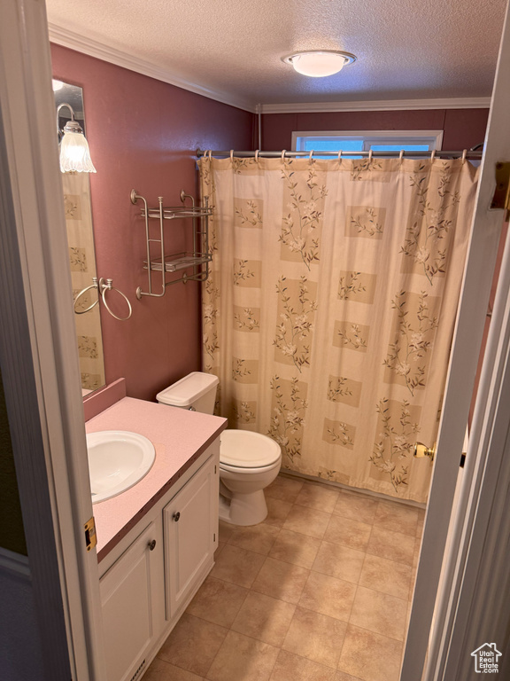 Full bathroom featuring a shower with curtain, a textured ceiling, vanity, toilet, and ornamental molding