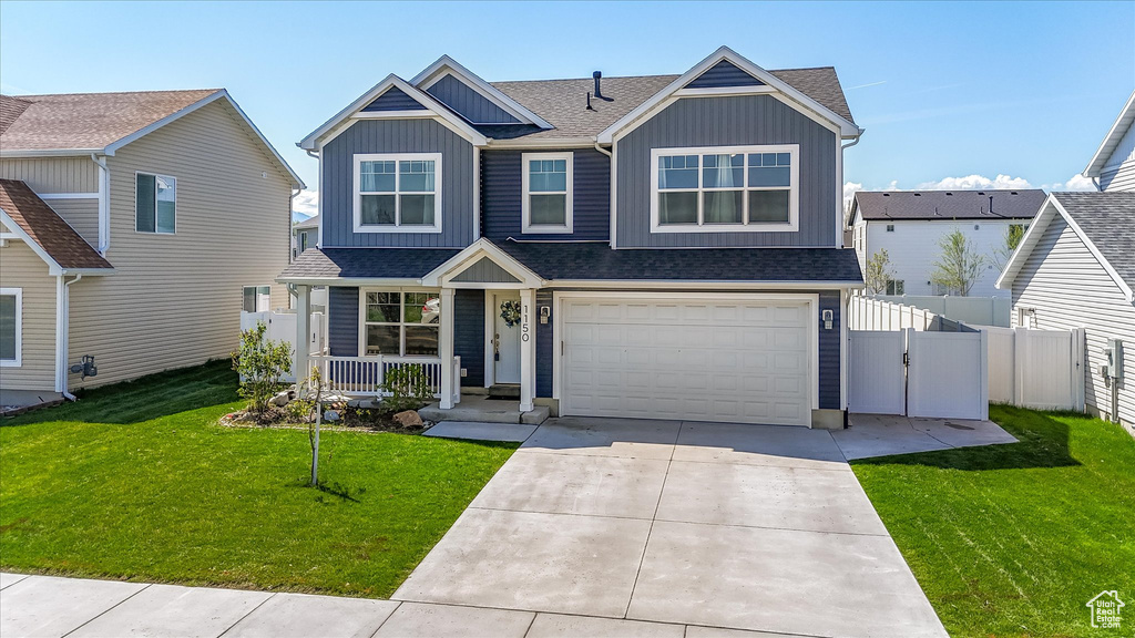 View of front of home featuring fence, roof with shingles, board and batten siding, a porch, and driveway
