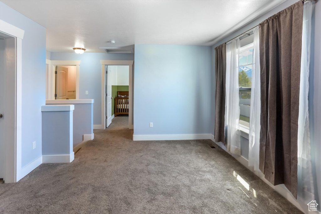 Carpeted spare room featuring baseboards