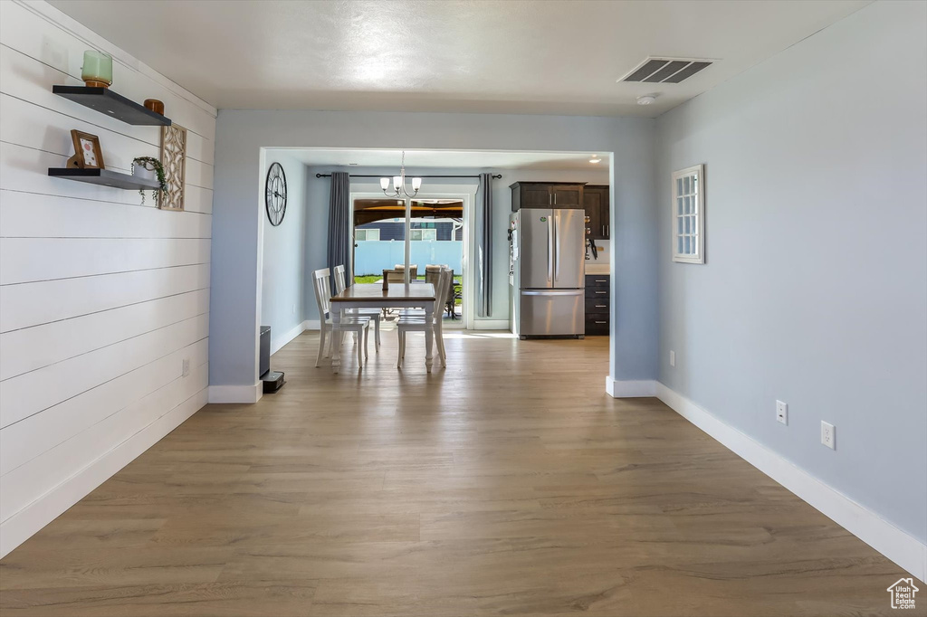 Dining area with baseboards, visible vents, an inviting chandelier, and wood finished floors