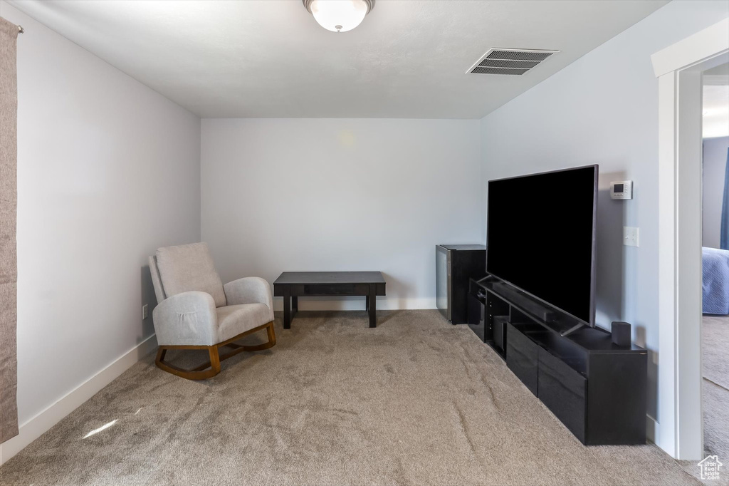 Living area with visible vents, carpet, and baseboards