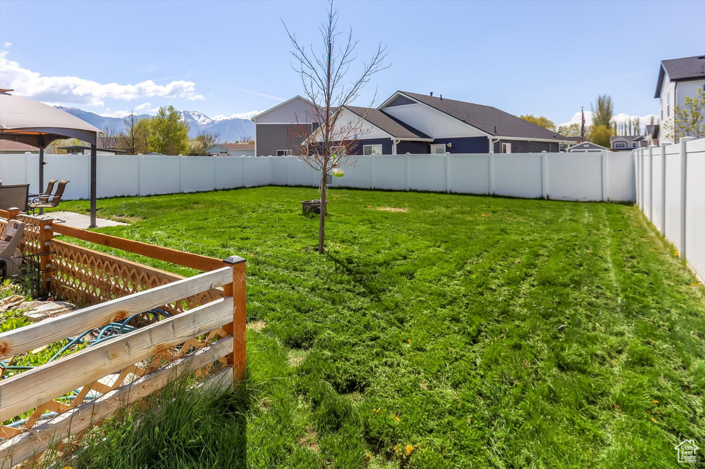 View of yard featuring a fenced backyard, a mountain view, and a gazebo
