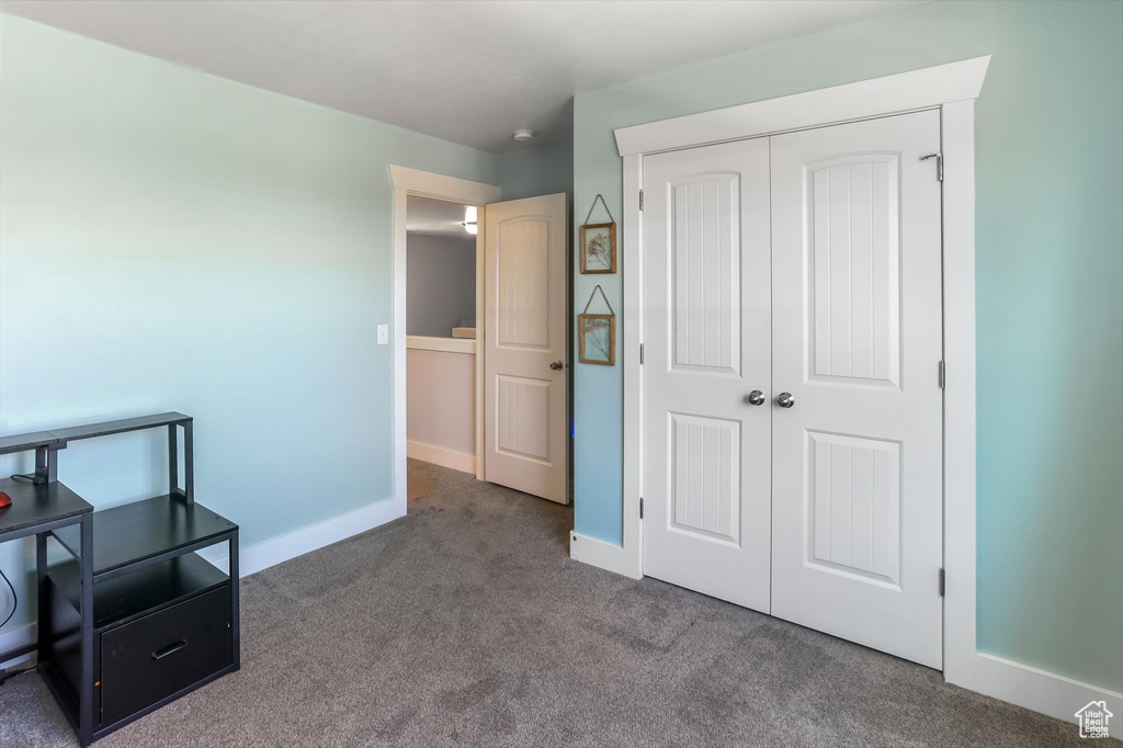 Carpeted bedroom with baseboards and a closet