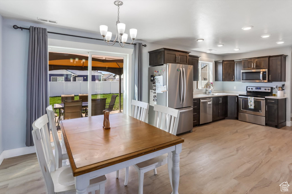 Dining space with visible vents, light wood-style floors, baseboards, recessed lighting, and a chandelier