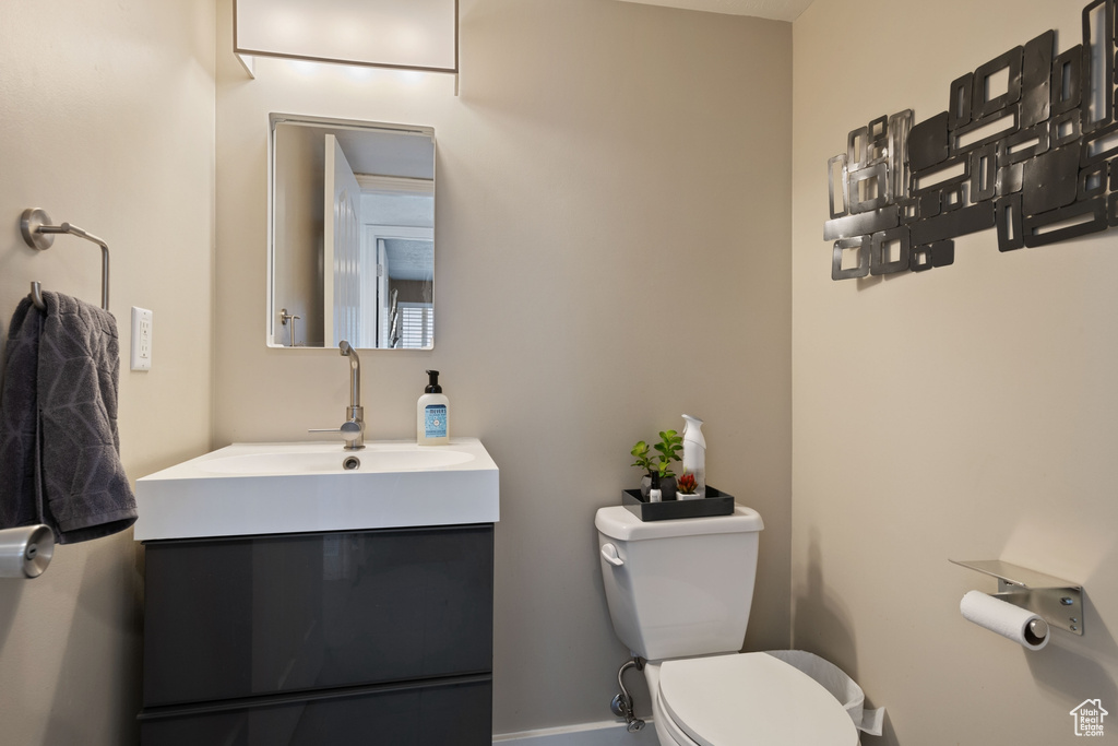 Bathroom with vanity, baseboards, and toilet
