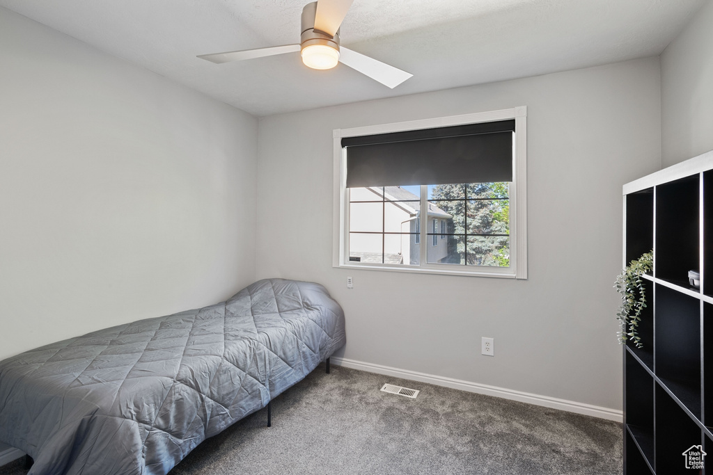 Carpeted bedroom with visible vents, a ceiling fan, baseboards, and a skylight
