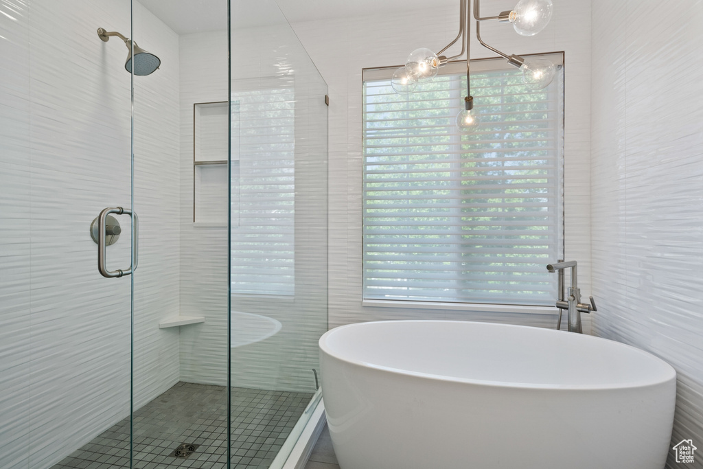 Full bath with a freestanding tub, tile walls, and a stall shower