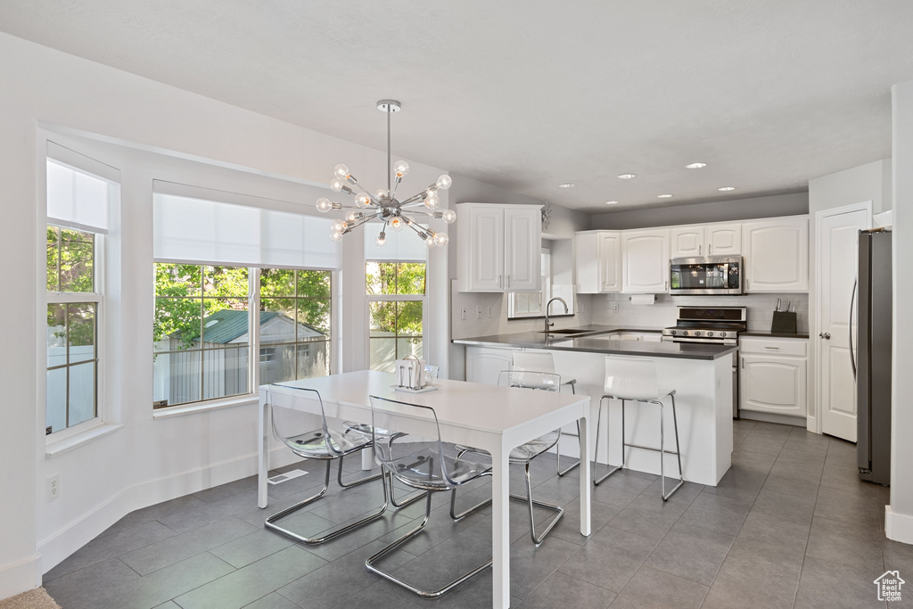Kitchen featuring white cabinets, appliances with stainless steel finishes, a healthy amount of sunlight, and a sink