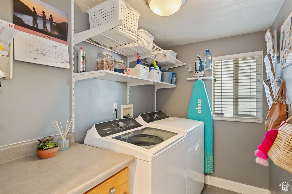 Washroom featuring laundry area, baseboards, and washer and dryer