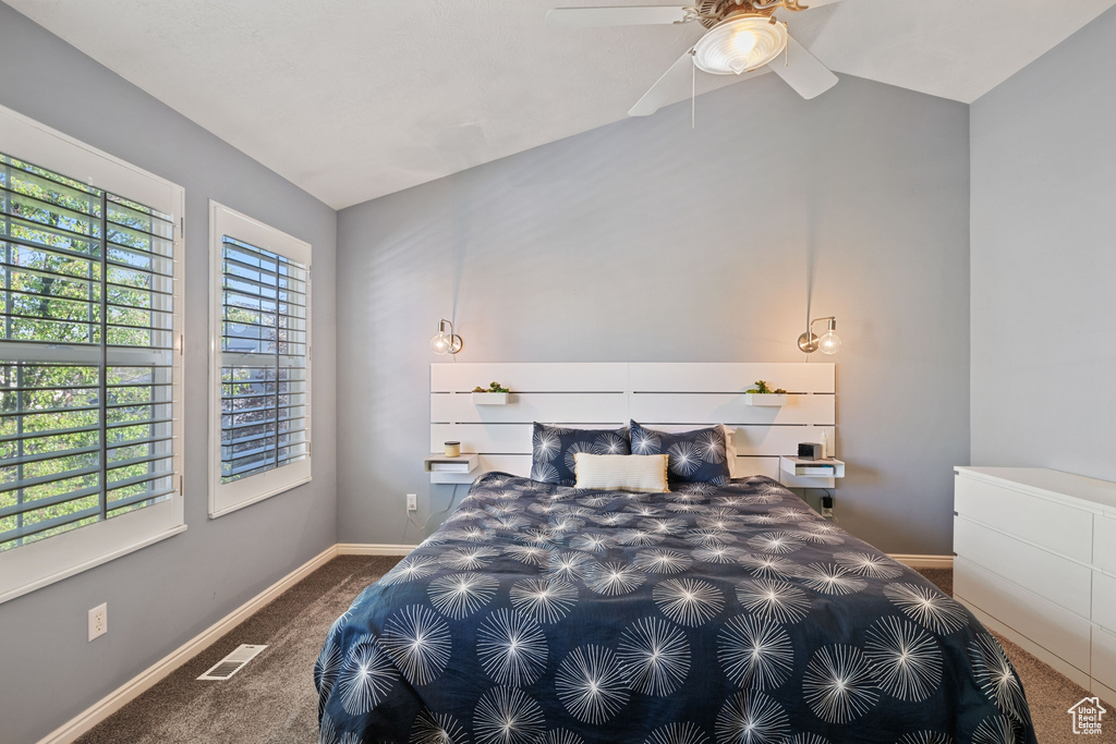 Carpeted bedroom featuring baseboards, visible vents, ceiling fan, and lofted ceiling