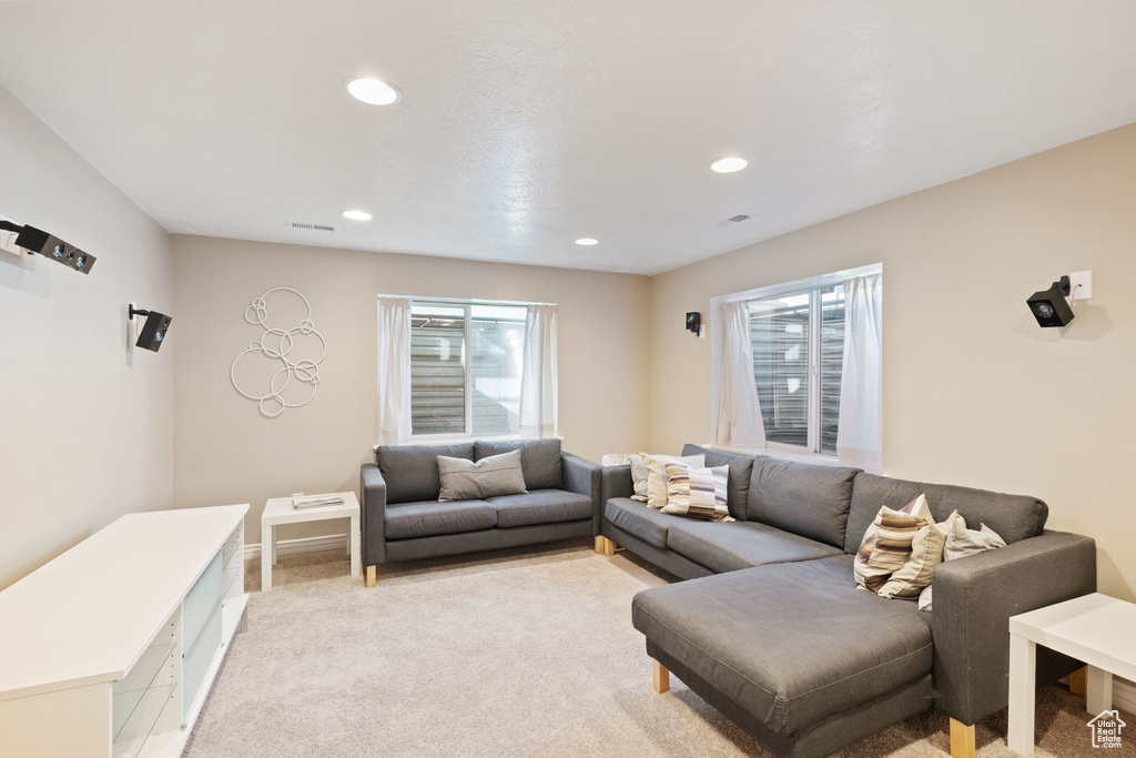 Living area featuring recessed lighting, baseboards, light colored carpet, and visible vents
