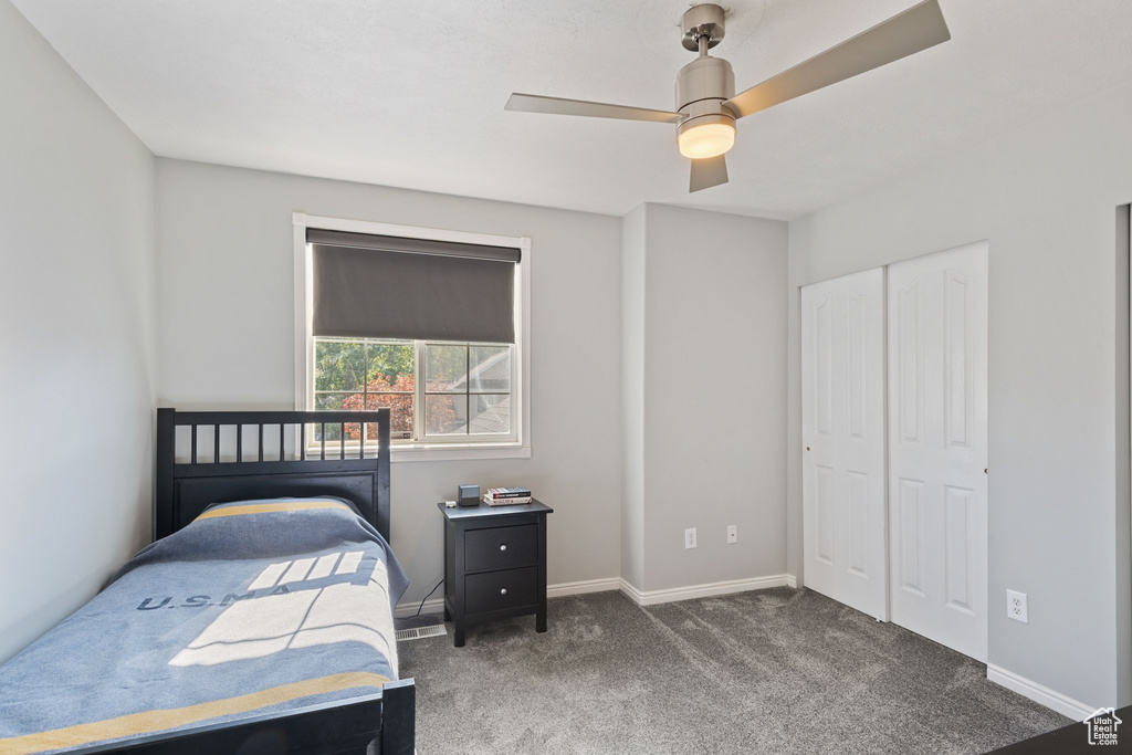 Bedroom with baseboards, ceiling fan, and carpet