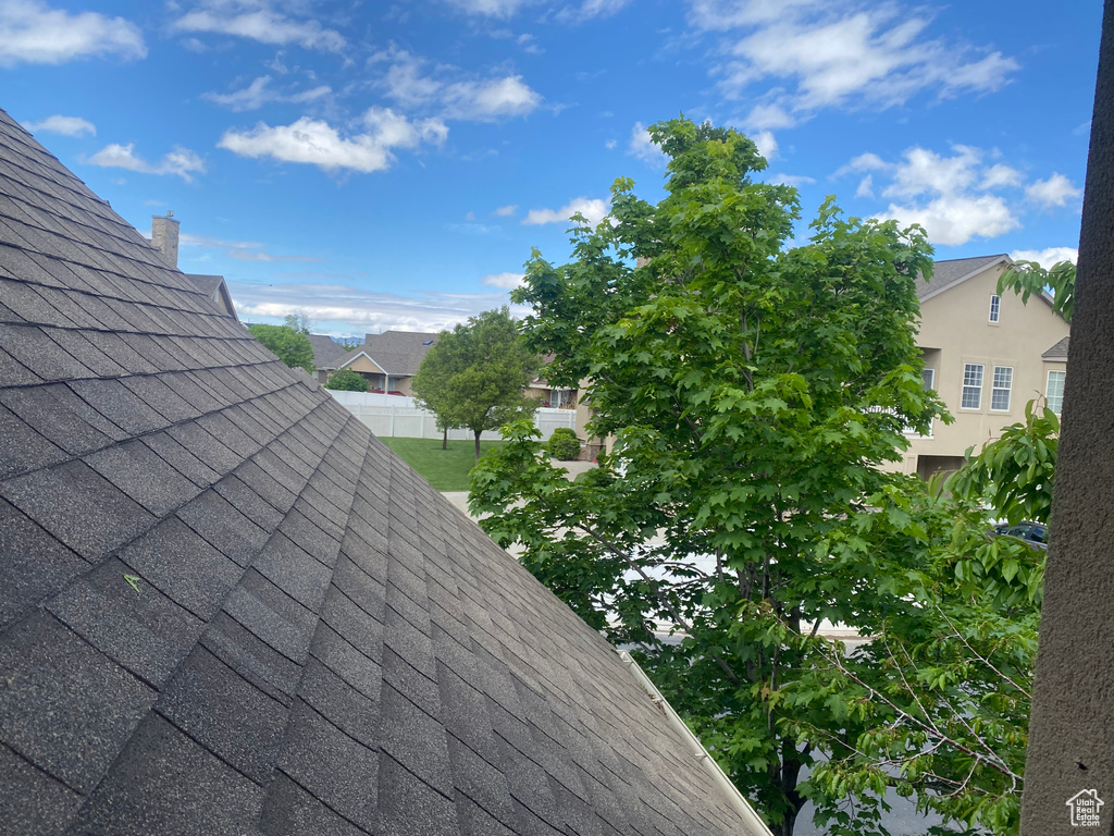 Details with a shingled roof, a chimney, fence, and a residential view