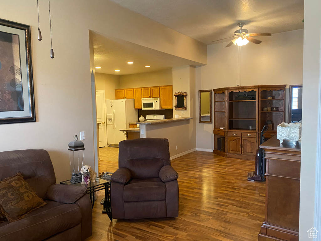 Living room featuring a ceiling fan, dark wood-style flooring, baseboards, and recessed lighting