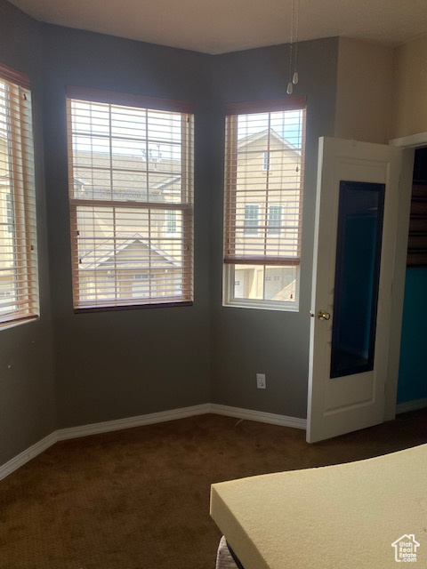 Unfurnished dining area with carpet floors and baseboards