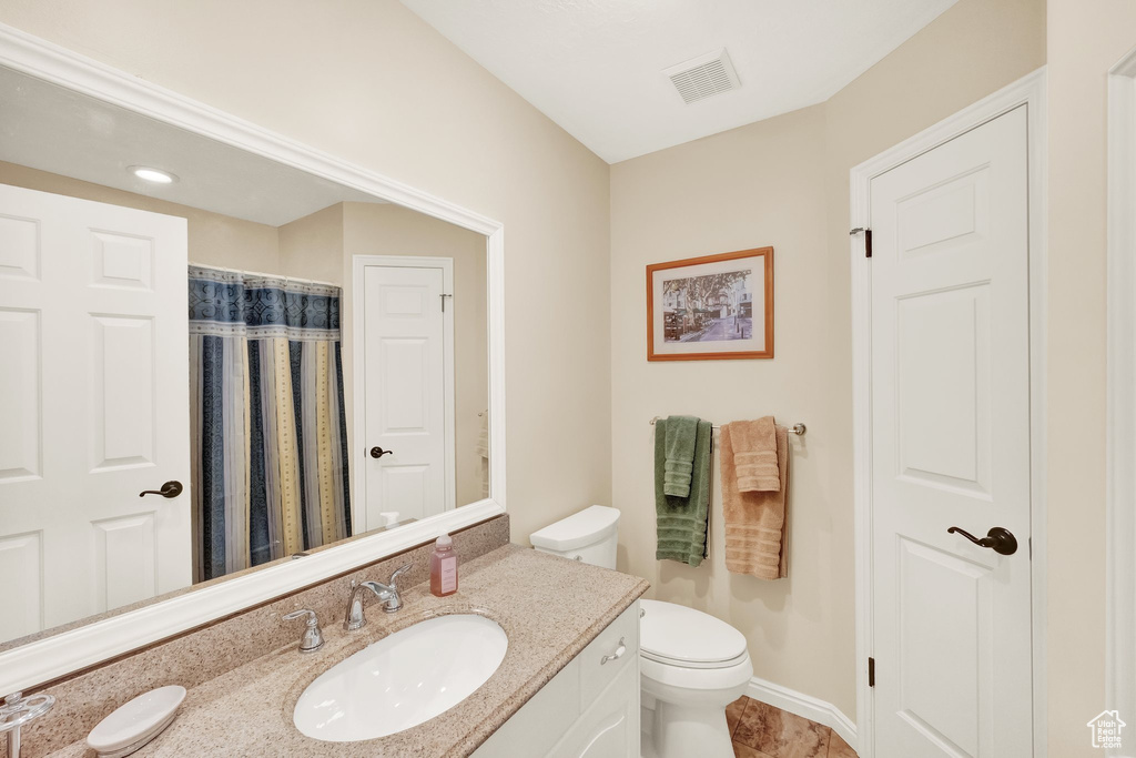 Bathroom with vanity, toilet, and visible vents