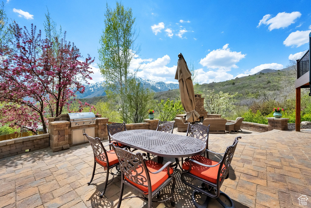 View of patio featuring area for grilling, a mountain view, outdoor dining space, and a grill
