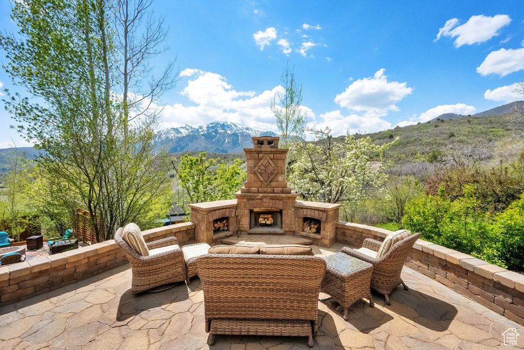 View of patio / terrace with a mountain view and an outdoor living space with a fireplace