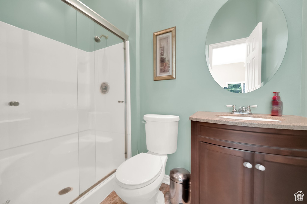 Bathroom featuring vanity, toilet, baseboards, and a stall shower
