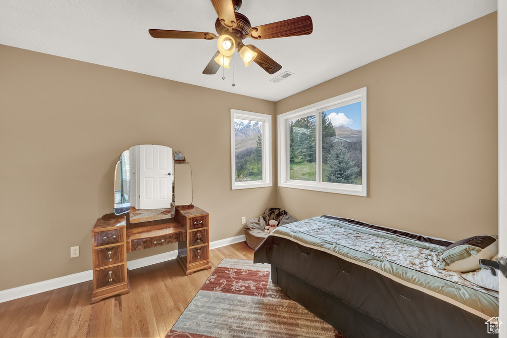 Bedroom with visible vents, a ceiling fan, baseboards, and light wood-style floors