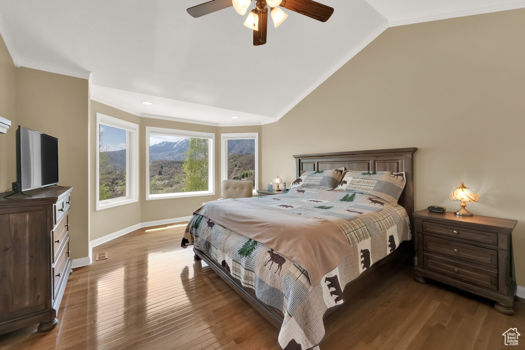 Bedroom featuring crown molding, baseboards, wood finished floors, and lofted ceiling