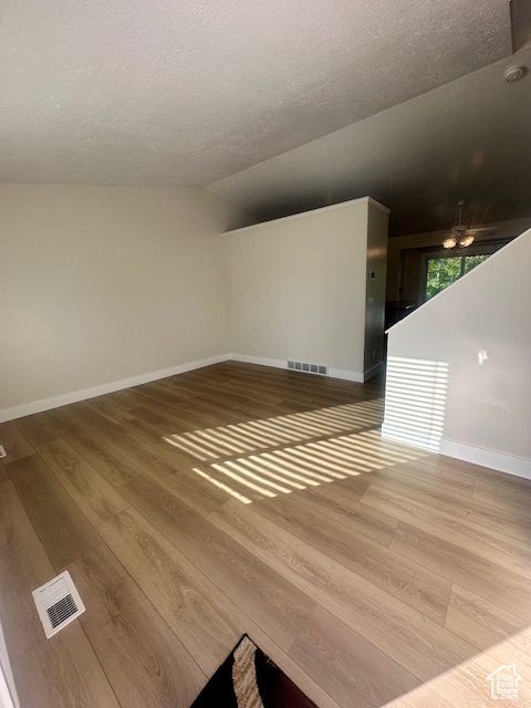 Interior space with a ceiling fan, baseboards, visible vents, and wood finished floors