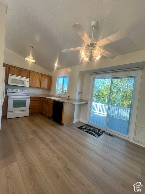 Kitchen with white appliances, light countertops, a textured ceiling, light wood-style flooring, and a ceiling fan