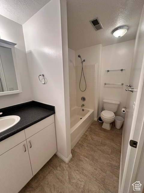 Bathroom featuring visible vents, a textured ceiling, toilet, and vanity