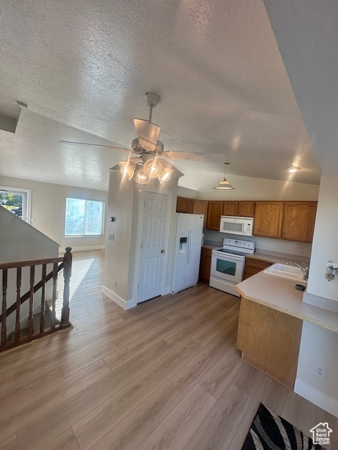 Kitchen featuring a sink, a textured ceiling, ceiling fan, and white appliances