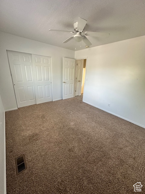 Unfurnished bedroom with visible vents, carpet flooring, baseboards, and a closet